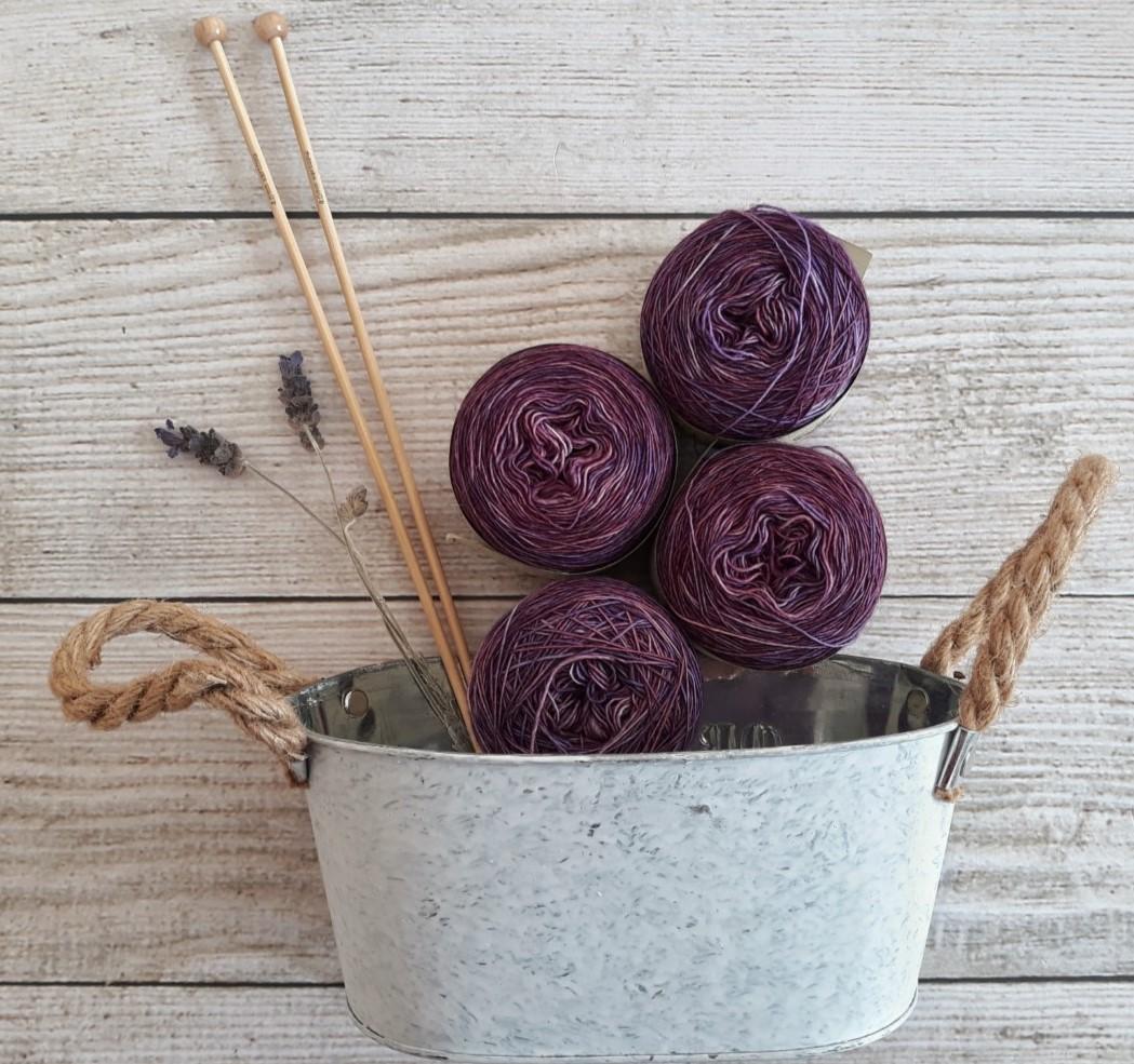 white bucket with purple yarn balls